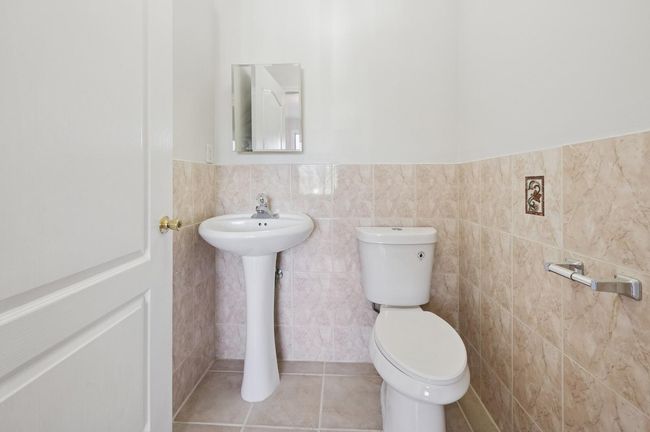 Half bath featuring wainscoting, toilet, tile patterned floors, and tile walls | Image 7