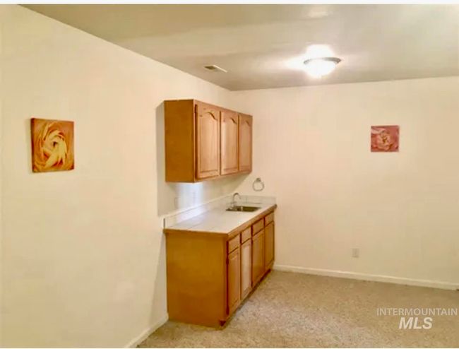 Additional area of bonus/craft room with sink, cabinets, baseboards and light carpet | Image 33