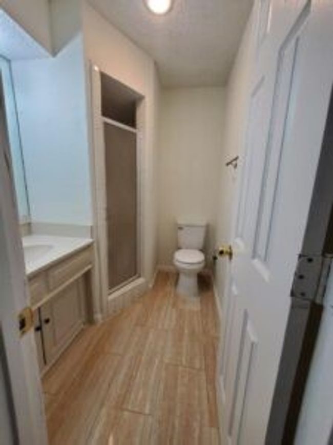 Full bathroom with vanity, a stall shower, and wood finished floors | Image 26