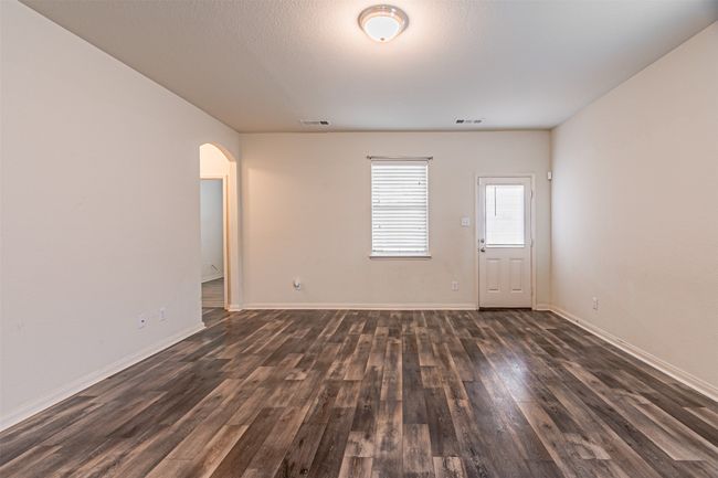 Empty room featuring arched walkways, dark wood-style flooring, and baseboards | Image 14