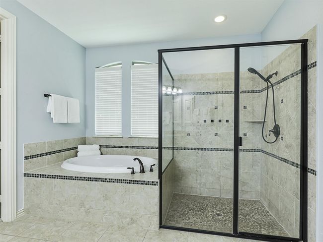 Bathroom with a bath, a stall shower, recessed lighting, and tile patterned floors | Image 23