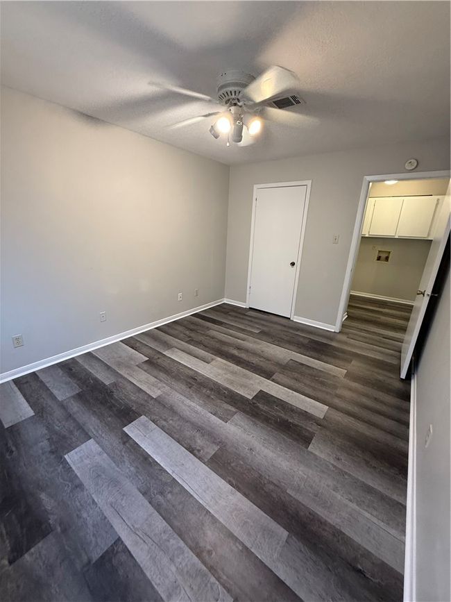 Unfurnished bedroom with dark wood-style floors, a ceiling fan, and a textured ceiling | Image 10