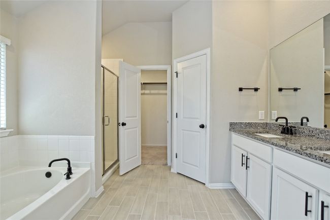 Full bath featuring vanity, a shower stall, a spacious closet, and a bath | Image 17