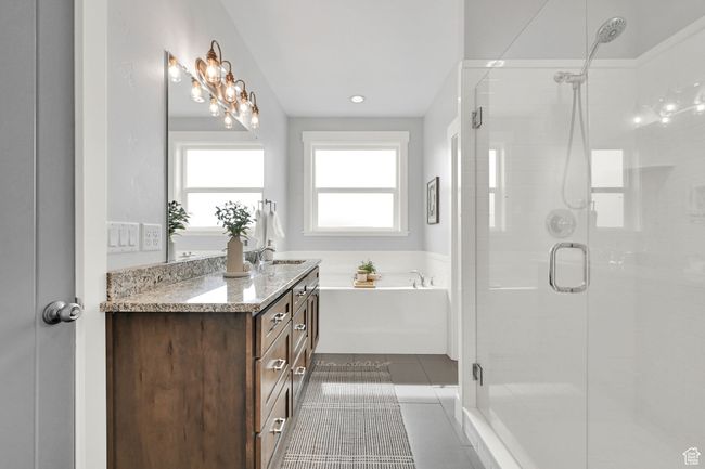 Bathroom featuring a stall shower, vanity, a garden tub, and tile patterned floors | Image 24