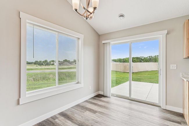 Dining area features a patio door that leads out to the backyard. | Image 12
