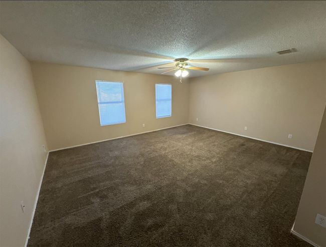 Carpeted spare room with a textured ceiling and ceiling fan | Image 20