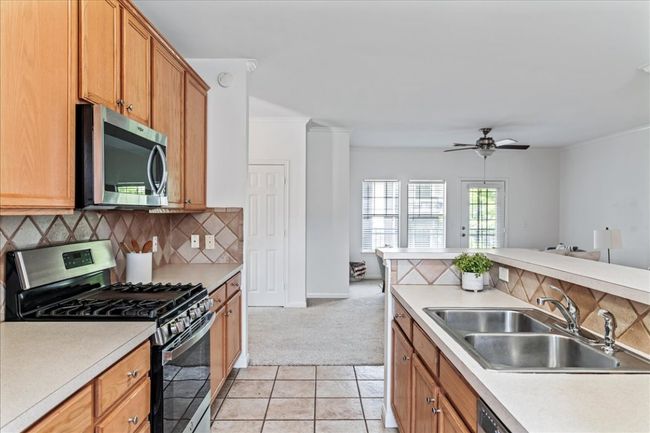 The kitchen overlooks the living area for ideal connection with friends and family. | Image 9