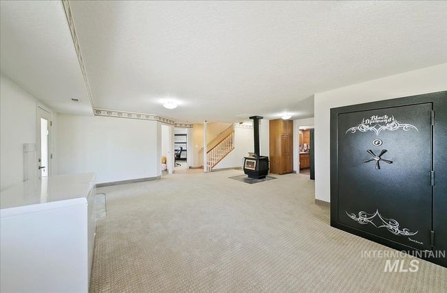 Basement featuring carpet floors, stairway, and a wood stove | Image 26