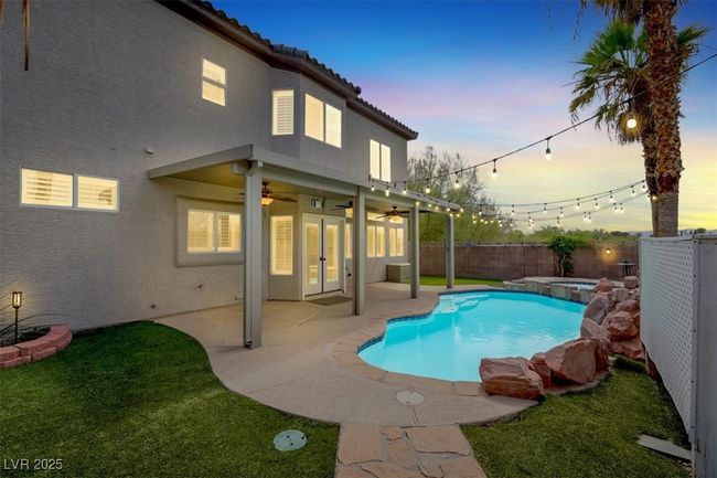 View of pool with a fenced backyard, ceiling fan, a pool with connected hot tub, and a patio | Image 42
