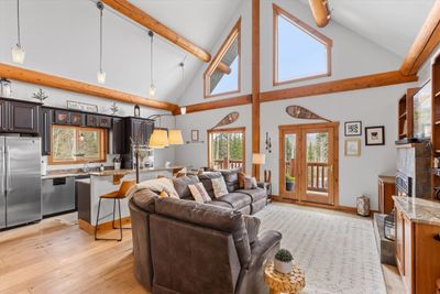 Open living, dining and kitchen areas, wood floors, gas fireplace, vaulted ceiling. | Image 3