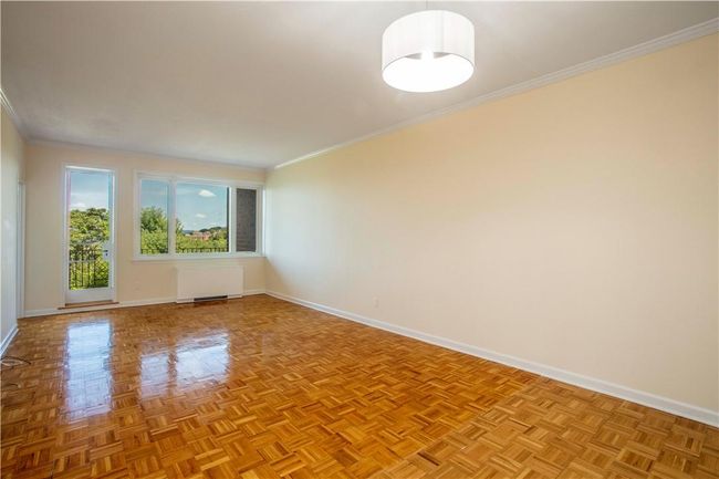 Alternate view of the huge Living Room with wood floors and new lighting. Young windows throughout the apartment. | Image 7