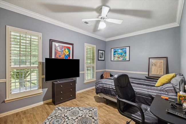 Charming two-story home with a welcoming front porch, nestled among mature trees. Features dormer windows, a classic gable roof, and a spacious yard, perfect for enjoying nature and outdoor activities. | Image 4