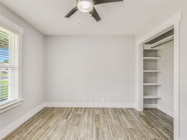 Unfurnished room featuring a wealth of natural light, ceiling fan, and wood finished floors | Image 16