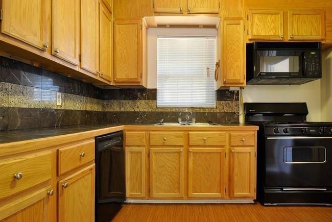 Kitchen with black appliances, tasteful backsplash, tile countertops, and light wood-style flooring | Image 7