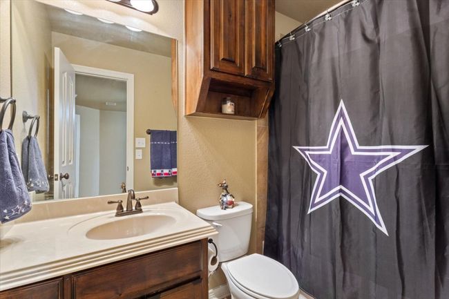 Bathroom with vanity, toilet, and a textured wall | Image 32