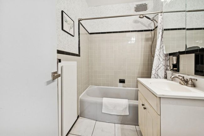 Full bath featuring shower / bath combo, vanity, and marble finish floors | Image 17