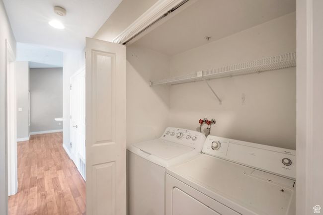 Washroom featuring washing machine and dryer and light wood-style floors | Image 9