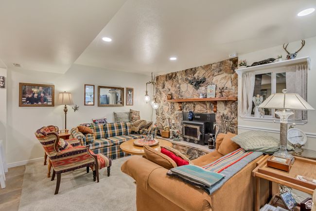 Living room featuring baseboards, a wood stove, and recessed lighting | Image 38