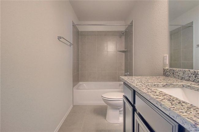 Full bath with vanity, toilet, tile patterned flooring, shower / bath combination, and baseboards | Image 35