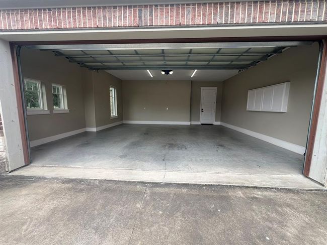 The attached oversized two-car garage offers ample space and features windows that bring in natural light, creating a bright, inviting space for your vehicles or additional storage. | Image 41