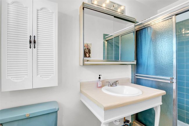Bathroom with toilet, an enclosed shower, and sink | Image 21