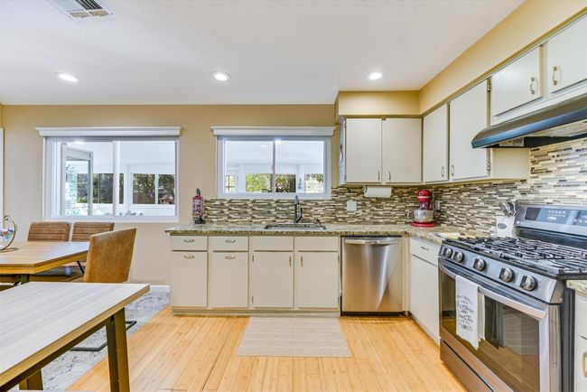 A wall of windows above the sink brings in natural light and frames the view into the expansive sunroom beyond | Image 6