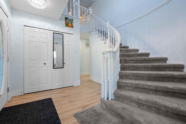 Entryway featuring a chandelier, stairway, baseboards, and wood finished floors | Image 22