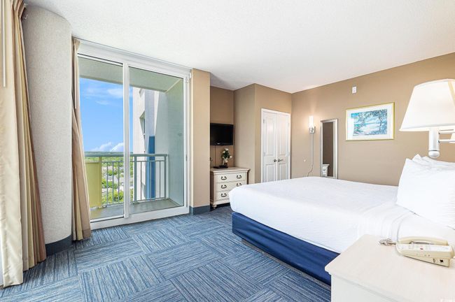 Bedroom featuring dark colored carpet, access to exterior, and baseboards | Image 13