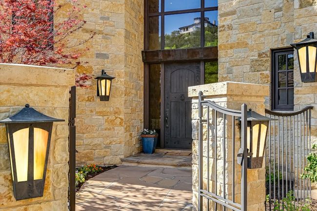 Doorway to property with stone siding, a gate, and fence | Image 4