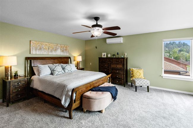 Carpeted bedroom featuring a wall unit AC and ceiling fan | Image 51