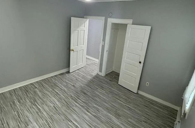 Unfurnished bedroom with baseboards and wood finished floors | Image 6