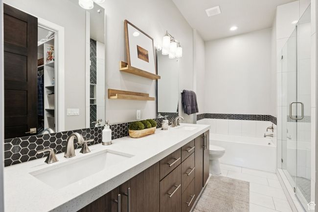 Bathroom featuring a garden tub, a shower stall, double vanity, tile patterned flooring, and a walk in closet | Image 24
