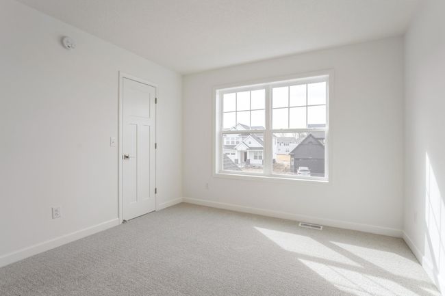 Photo is of the actual home. One of three generously sized secondary bedrooms with a spacious closet. | Image 11