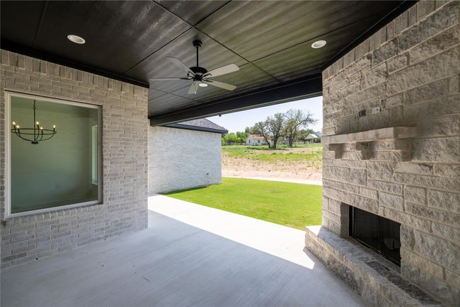 View of patio / terrace with an outdoor stone fireplace and ceiling fan | Image 35