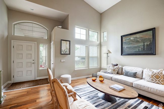 Living area with a stone fireplace, wood finished floors, and a high ceiling | Image 4