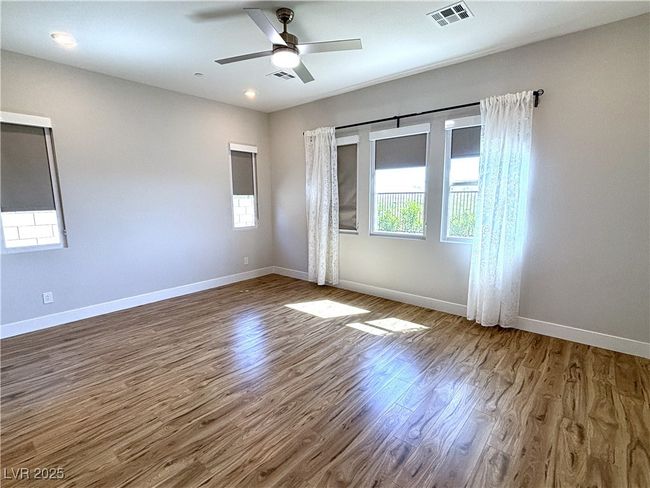 Spare room with baseboards, visible vents, and wood finished floors | Image 22