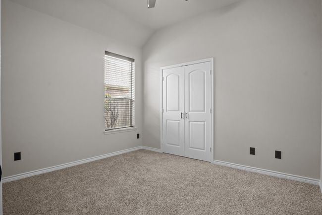 Unfurnished bedroom with carpet flooring, a ceiling fan, baseboards, lofted ceiling, and a closet | Image 25