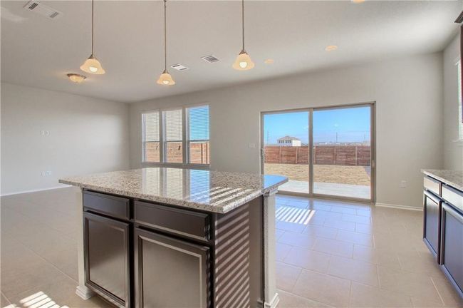 Kitchen featuring baseboards, decorative light fixtures, light stone countertops, and light tile patterned floors | Image 7