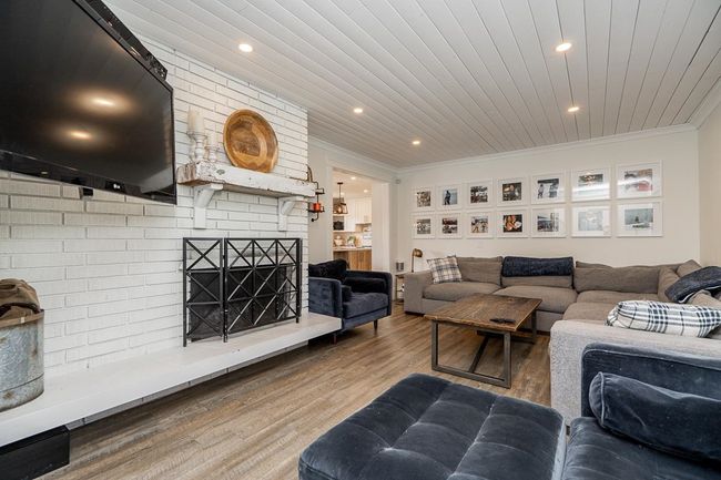 Living room with ornamental molding, recessed lighting, wood finished floors, and a fireplace | Image 11