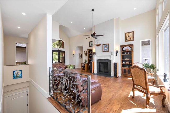 Living room with high vaulted ceiling, light wood-type flooring, a tiled fireplace, a ceiling fan, and recessed lighting | Image 43