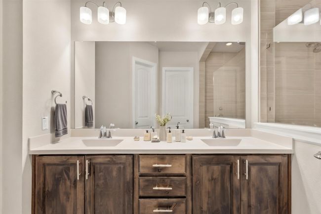 Bathroom featuring double vanity and tiled shower | Image 21
