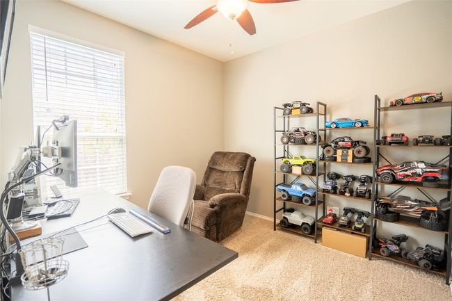 Carpeted home office featuring ceiling fan and healthy amount of natural light | Image 19