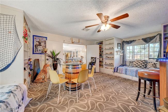 Carpeted dining area featuring a ceiling fan and a textured ceiling | Image 20