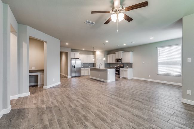 Unfurnished living room featuring light wood-type flooring, sink, and ceiling fan | Image 8