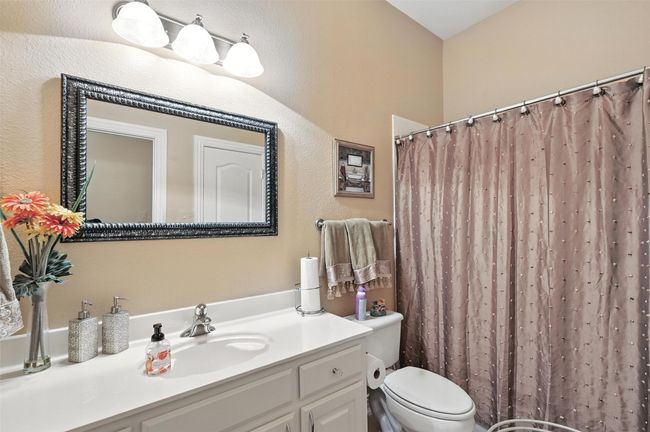 Bathroom featuring vanity and curtained shower | Image 16