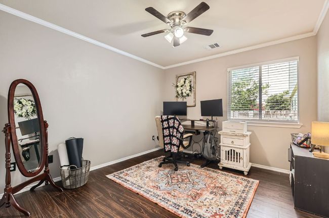 Office space featuring ornamental molding, wood finished floors, and a ceiling fan | Image 15