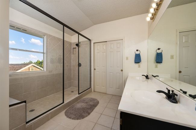 Bathroom with a shower stall, double vanity, a sink, and tile patterned flooring | Image 26