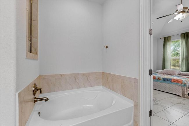Bathroom featuring double vanity, tile patterned flooring, and shower / bath combo with shower curtain | Image 17