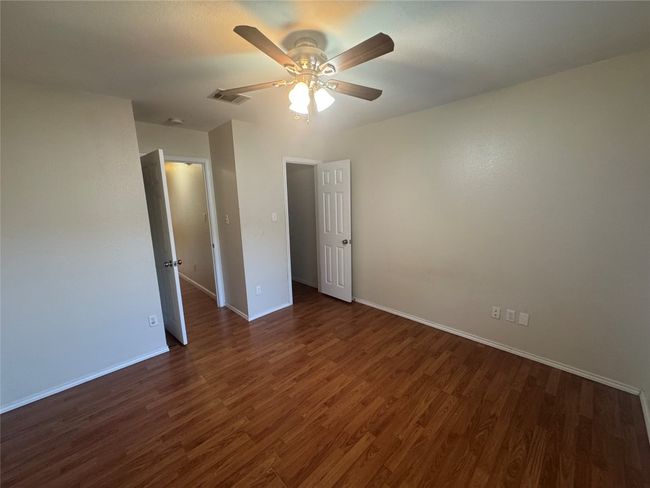 Unfurnished room with dark wood-type flooring and a ceiling fan | Image 10