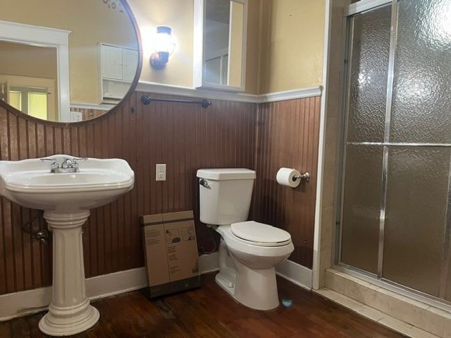 Bathroom with a wainscoted wall, a shower stall, and wood finished floors | Image 21